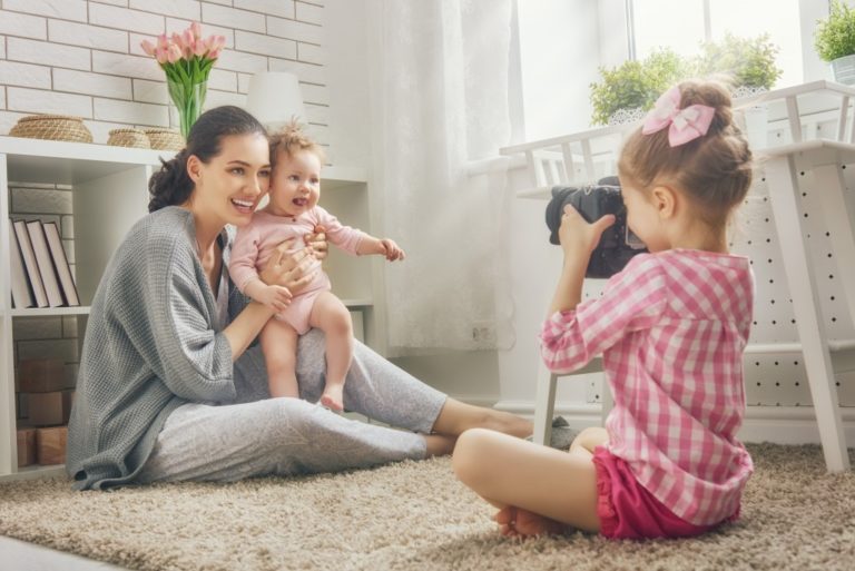 Girl taking a photo of her mom and sister