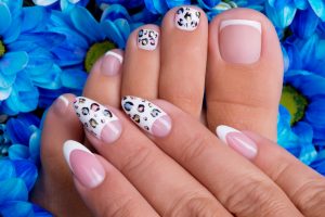 woman's nails of hands and legs with beautiful french manicure and art design